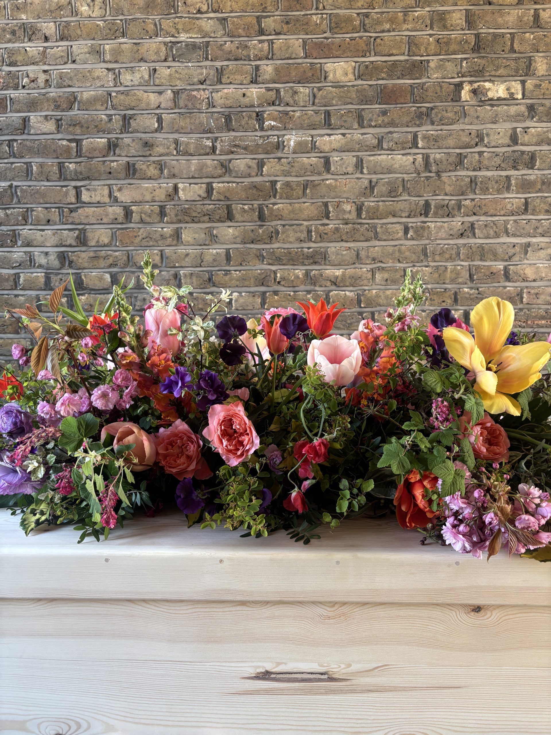 Bright, wild flower coffin top arrangement