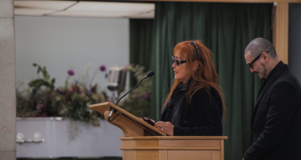 Family member delivering a reading during a bespoke cremation service