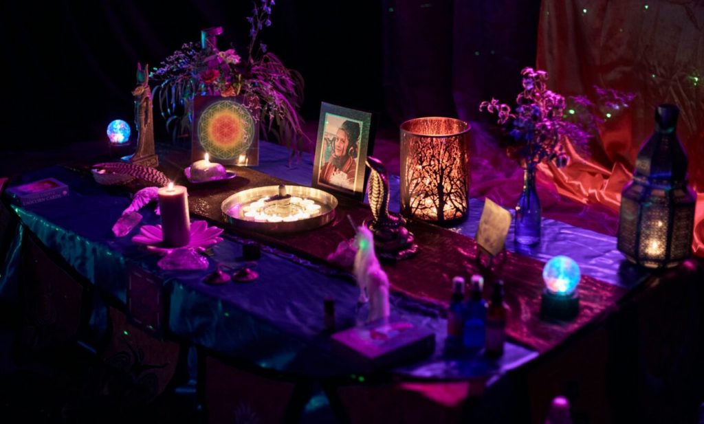 Decorated altar with candles, artwork and symbolic objects during a memorial ceremony