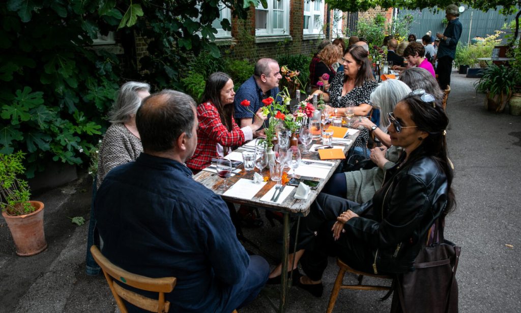 Group of people dining together outdoors at a funeral remembrance gathering