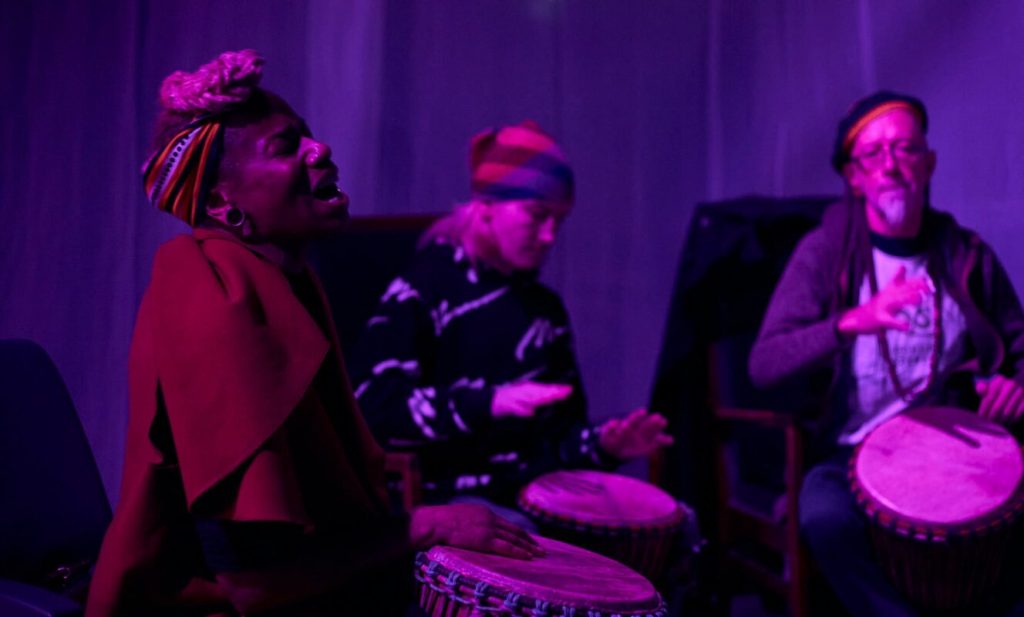 Group playing drums together as part of a celebration of life ritual