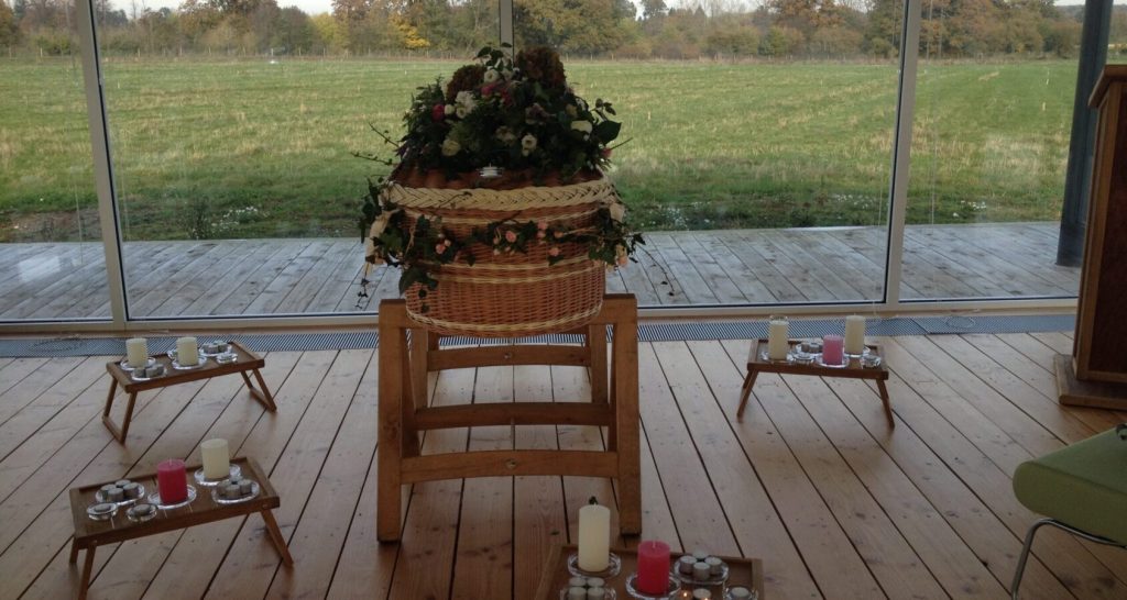 Chapel set for an intimate natural burial ceremony overlooking meadow landscape