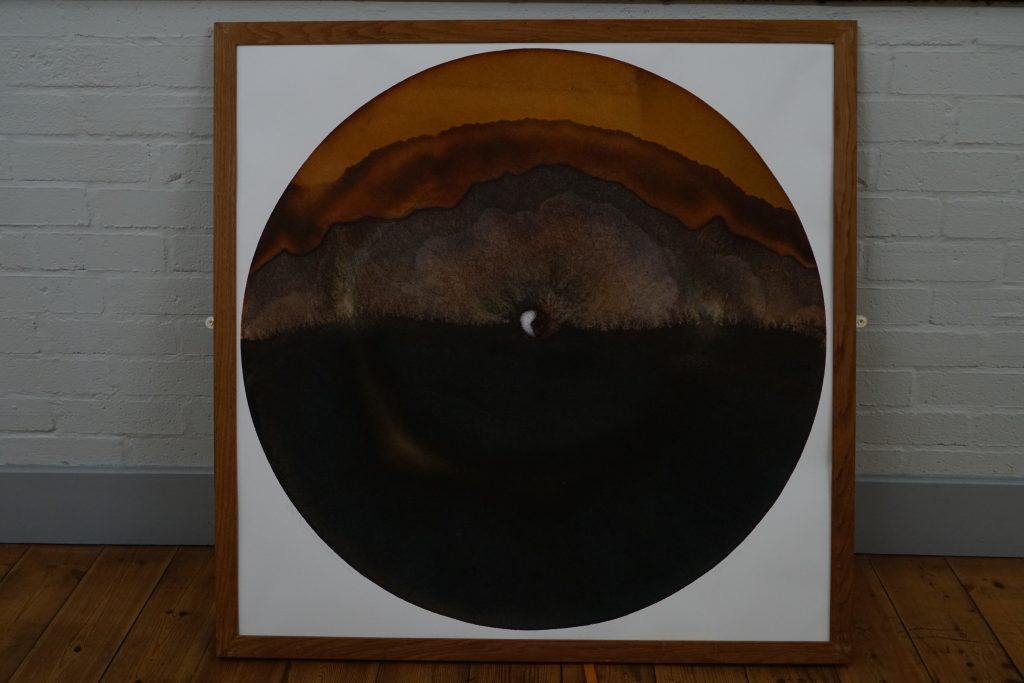 Framed circular ash art memorial artwork displayed against wall