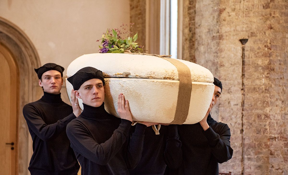 Thereafter Funeral Services Pallbearers dressed in all black with hat carry Mycelium Living Cocoon coffin in Abney Park Chapel, London N16