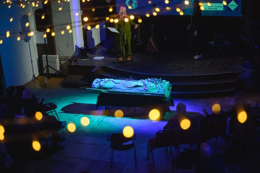 Sacred Wings Shroud in blue light at a wake