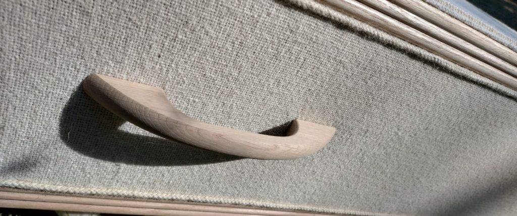 Natural colour British Wool eco-friendly coffin made by The Woollen Cwtch Company. Close up of sustainable wooden handle
